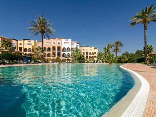 a swimming pool in a resort with palm trees and buildings at Jardim da Meia Praia Apartment in Lagos