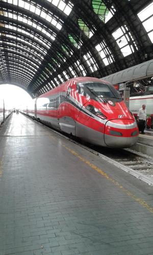 a red train is parked in a train station at "LA TAVERNA" B&B in Airuno