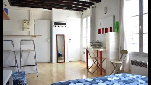 パリにあるCosy 25 sqm Studio in Heart of Parisのキッチン(テーブル、椅子付)が備わる客室です。