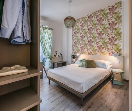 a bedroom with a bed and a wall with flowers at Lele Rooms San Lorenzo in Rome
