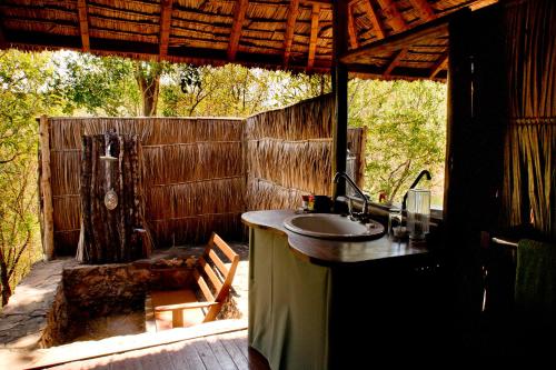 a bathroom with a sink and a fence at Sable Mountain Lodge, A Tent with a View Safaris in Kisaki