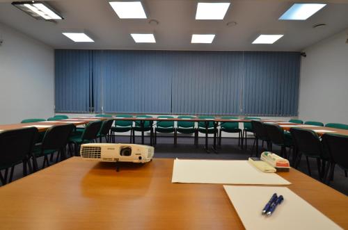 an empty classroom with tables and chairs and a computer on the table at Hotel Stawisko Klaudyn in Klaudyn