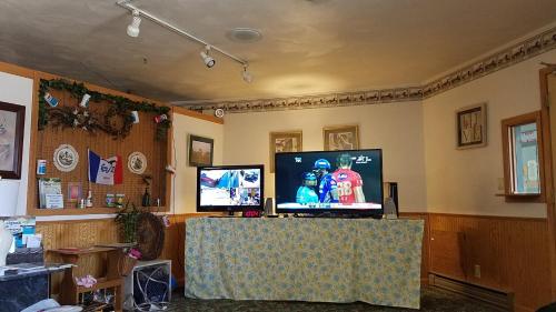 a living room with a tv and a table with a screen at Burr Oak Motel in Algona