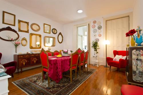 a dining room with a table and red chairs at Casa Portugueza Experience in Porto