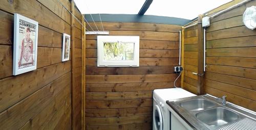uma cozinha com paredes de madeira e um lavatório em Gîte Studio Tarbes Pyrénées em Tarbes