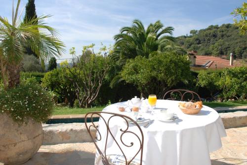 een tafel met een witte tafeldoek en een fruitschaal bij Les Orangers in Saint-Paul-de-Vence