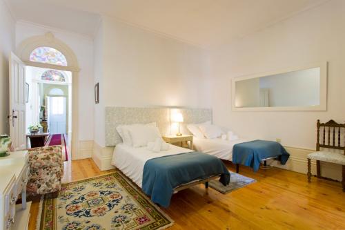 a bedroom with two beds and a couch and a window at Casa Portugueza Experience in Porto