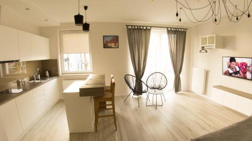 Una cocina con dos sillas y una mesa en una habitación. en Apartament Termalny Komfort 8.2, en Uniejów