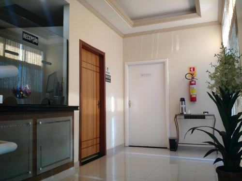 a hallway with a door and a potted plant at Dok Brasília Hotel Unidade Águas Claras in Taguatinga