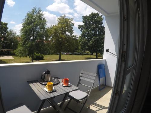 einen kleinen Tisch und Stühle auf einem Balkon mit Fenster in der Unterkunft F2 - Am alten Elbarm - Laubegast in Dresden