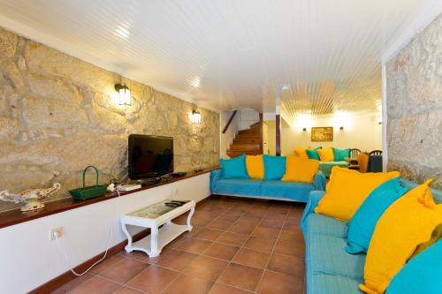 a living room with a blue couch and a tv at Casa Portugueza Experience in Porto