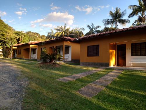 une maison avec une pelouse devant elle dans l'établissement Pousada Paraiso, à Serra Negra