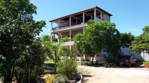 ein Gebäude mit einem davor geparkt in der Unterkunft Pousadinha Mangabeiras Familia e Grupos in Guriri