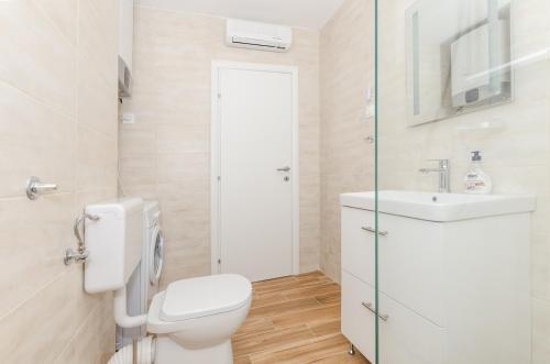 een witte badkamer met een toilet en een wastafel bij Down town oaza in Rijeka