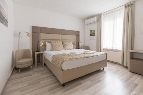 um quarto com uma cama grande e uma cadeira em Residence Mutschellen em Zurique