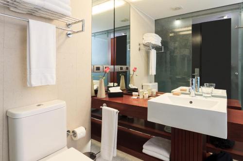 a bathroom with a toilet, sink, and shower at Hotel Ismael in Santiago