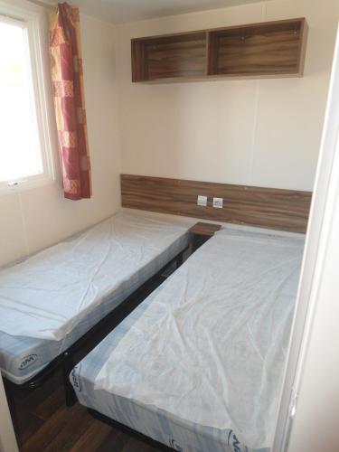 deux lits dans une petite pièce avec une fenêtre dans l'établissement la carabasse, à Vias