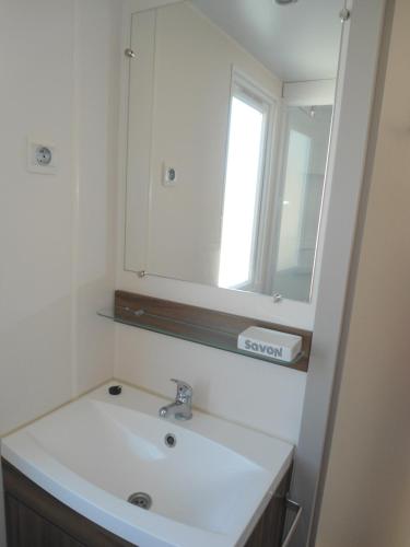 une salle de bain avec un lavabo et un miroir dans l'établissement la carabasse, à Vias