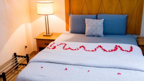 a bedroom with a bed with red flower petals on it at The Jam Lodge in Freetown