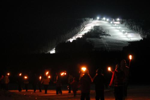 a group of people holding lit candles at night at Hotel Schäfflerhof in Bischofsmais
