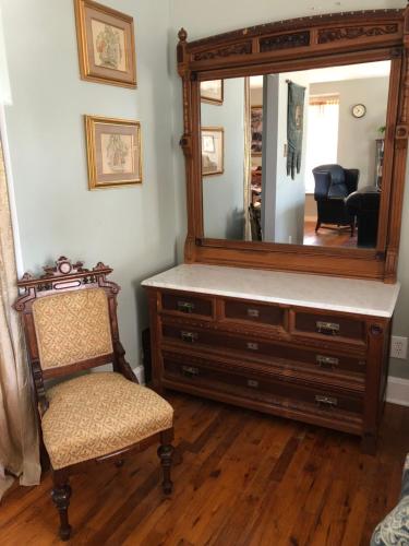 a dresser with a mirror and a chair in a room at Vineyard Mansion Carriage House in Saint Joseph