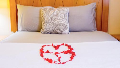 a heart made out of flowers on a bed at The Jam Lodge in Freetown
