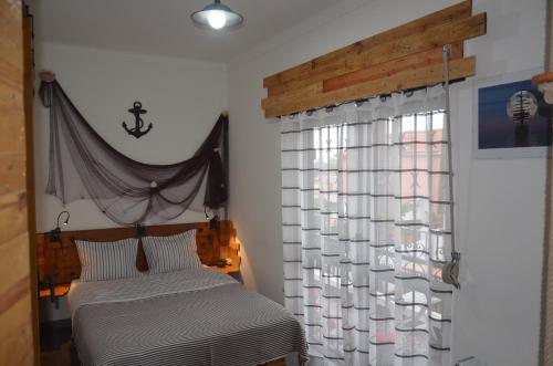 a bedroom with a bed and a window at Os Piratas in Charneca