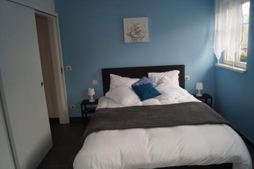 HazelbourgにあるLe Valsbergの青い壁のベッドルーム1室(大型ベッド1台付)