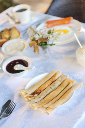a white table with plates of food on it at Hotel Simpatia in K'obulet'i
