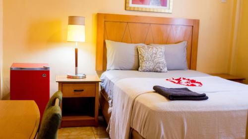 a hotel room with a bed with a white bedspread at The Jam Lodge in Freetown