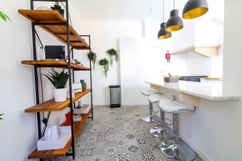 リスボンにあるAvenidas Cozy Apartmentのキッチン(木製の棚、カウンター、スツール付)
