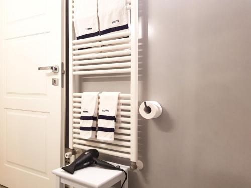 a bathroom with a white towel rack with towels at Villa Belmonte in Favara