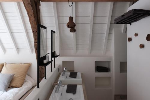 a bathroom with white walls and a sink and a couch at Boutique Holiday Home ZaligInAntwerpen 77 in Antwerp