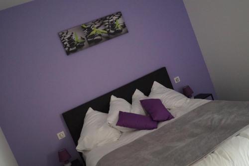 a bedroom with a bed with purple walls and purple pillows at La Schleif in Hazelbourg