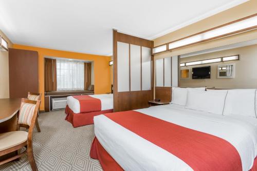Habitación de hotel con 2 camas y mesa en Microtel Inn and Suites by Wyndham Anderson SC, en Anderson