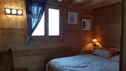 a bedroom with a bed in a log cabin at Chez Liadet in Mouthe