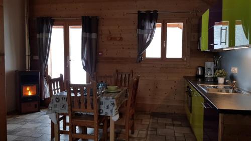 a kitchen with a table and chairs and a stove at Chez Liadet in Mouthe