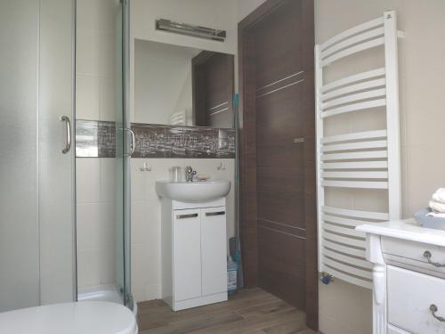 a bathroom with a shower and a sink and a mirror at Pokoje na Jasnej in Kołobrzeg