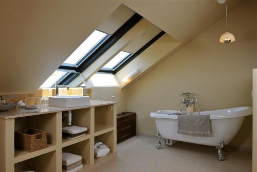 a attic bathroom with a tub and a sink at B&B Sapere in Genoelselderen
