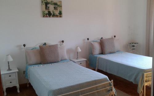 a bedroom with two beds with blue sheets at Monte da Cardela Nova in Melides