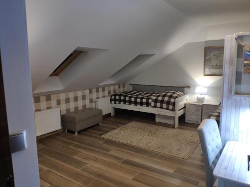 a attic room with a bed and a chair at Pokoje na Jasnej in Kołobrzeg