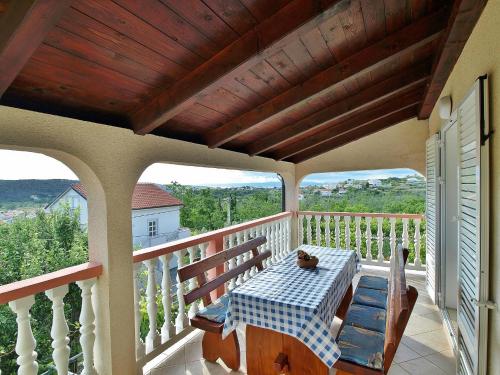 a porch with a table and chairs on a balcony at Apartmani Roza Lopar in Lopar