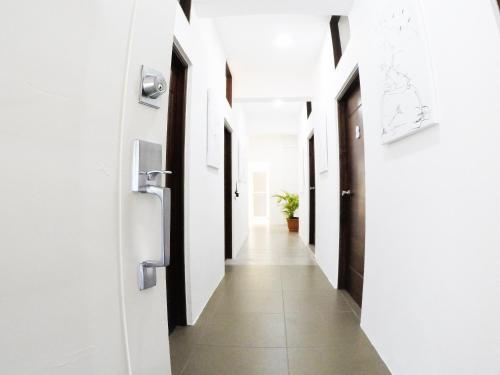 a hallway with white walls and a long corridor at Whostal in Santiago de los Caballeros