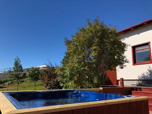 a hot tub on a deck next to a house at Grýtubakki I in Grenivík