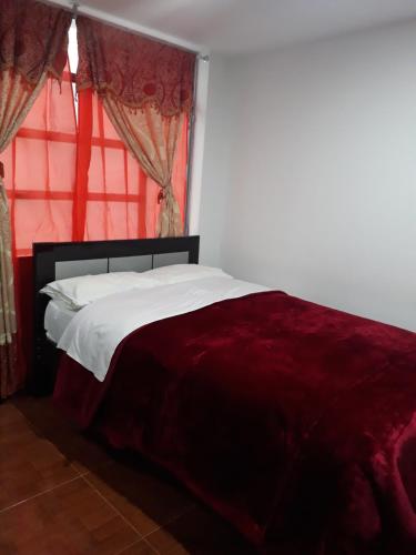 a bedroom with a red and white bed with a window at Hotel Royal Class in Ipiales