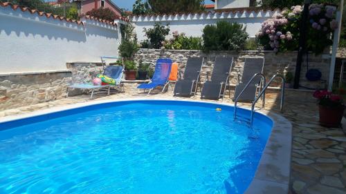 a large swimming pool with chairs and a pool at Apartments Val in Umag