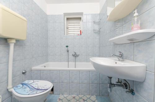 een badkamer met een wastafel, een toilet en een bad bij Apartment Damir in Primošten
