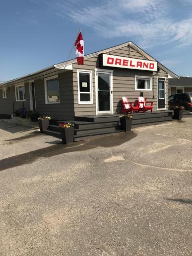 a mobile inn with two red chairs in a parking lot at Oreland Motel in Flin Flon