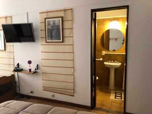 a bathroom with a sink and a mirror at Ruffus's Apple Mardel in Mar del Plata