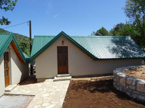 a small white house with a green roof at Apartmani Vinici in Danilovgrad